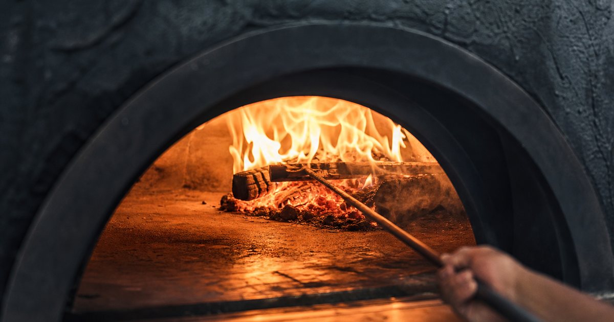 How long does a premium pizza oven take to reach cooking temperature?